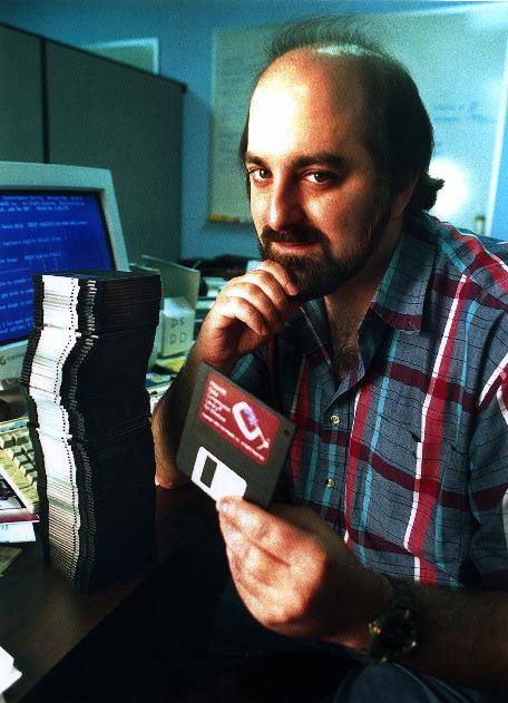 Phil Katz at his desk with a stack of floppy disks.